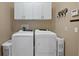The Laundry Room features a side-by-side washer and dryer and ample cabinet space at 7657 Caponata Blvd, Seminole, FL 33777