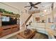 Bright living room with soaring ceilings, a cozy seating area, and an open staircase with iron railings at 7657 Caponata Blvd, Seminole, FL 33777