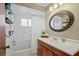 This bathroom features a white vanity with wood trim, a decorative mirror, and a shower/tub combo at 8763 Matthew St, Seminole, FL 33772