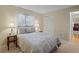 This bedroom features neutral decor, a window with white curtains, and a closet with white doors at 8763 Matthew St, Seminole, FL 33772