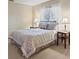 This bedroom features neutral decor, a window with white curtains, and two side tables at 8763 Matthew St, Seminole, FL 33772