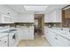 Well-lit kitchen featuring white cabinetry, backsplash, and countertops, with view into dining area at 8763 Matthew St, Seminole, FL 33772