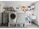 Bright laundry room with washer, dryer, storage shelves, utility sink, and water heater at 8763 Matthew St, Seminole, FL 33772