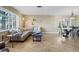 Open-concept living space features a sectional sofa, dining area, neutral paint, and tiled floors throughout at 8763 Matthew St, Seminole, FL 33772