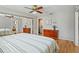 This main bedroom features a ceiling fan, wood dresser, ensuite bath and hardwood floors at 8763 Matthew St, Seminole, FL 33772