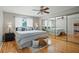 This main bedroom features a ceiling fan, mirrored closet doors, and gleaming hardwood floors at 8763 Matthew St, Seminole, FL 33772