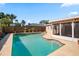 Inviting backyard pool featuring well-maintained landscaping, concrete pool deck and a privacy fence at 8763 Matthew St, Seminole, FL 33772