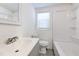 Bright bathroom with a large sink, toilet, and walk-in shower and gray tile flooring at 905 W Ball St, Plant City, FL 33563