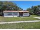 A single-story home showing boarded up windows and front yard at 9355 Pinero St, Spring Hill, FL 34608