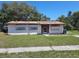 A single-story home showing boarded up windows and front yard at 9355 Pinero St, Spring Hill, FL 34608