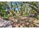 Spacious, grassy backyard shaded by mature oak trees with a shed and swing at 9724 Hermit Hollow Ln, Gibsonton, FL 33534