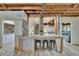 Featuring a bar with marble counters, stools, an open floor plan, and a view into the living room area at 9724 Hermit Hollow Ln, Gibsonton, FL 33534