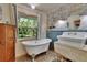 Vintage-style bath features clawfoot tub, unique sink, wood-look flooring, and stone wall at 9724 Hermit Hollow Ln, Gibsonton, FL 33534