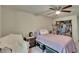 Cozy bedroom featuring a ceiling fan, open closet and bedside table with an additional chair at 9724 Hermit Hollow Ln, Gibsonton, FL 33534