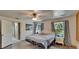 Bright bedroom with hardwood floors, ceiling fan, and lots of natural light from the two windows at 9724 Hermit Hollow Ln, Gibsonton, FL 33534