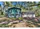 Exterior view of the home featuring green siding and a two-car garage at 9724 Hermit Hollow Ln, Gibsonton, FL 33534