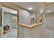 Bright hallway with decorative wood trim leads to a bathroom with marble floors and natural light at 9724 Hermit Hollow Ln, Gibsonton, FL 33534