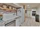 Bright kitchen featuring white cabinets, floating shelves, and a vintage farmhouse sink at 9724 Hermit Hollow Ln, Gibsonton, FL 33534