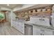 Bright kitchen with white cabinets, floating wood shelves, and an oversized white farmhouse sink at 9724 Hermit Hollow Ln, Gibsonton, FL 33534