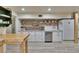 Bright kitchen with white cabinets, floating wood shelves, and an oversized white farmhouse sink at 9724 Hermit Hollow Ln, Gibsonton, FL 33534
