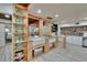 Well-lit kitchen featuring wooden shelving, white cabinetry, and white farmhouse sink at 9724 Hermit Hollow Ln, Gibsonton, FL 33534