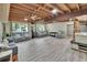 Spacious living room with wood plank ceiling, light grey flooring, and lots of seating at 9724 Hermit Hollow Ln, Gibsonton, FL 33534