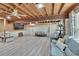 Open living room with wood plank ceiling, light grey flooring, and blue couches at 9724 Hermit Hollow Ln, Gibsonton, FL 33534