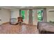 Spacious living area with three windows, mosaic tile floors, a brown leather chair, and cozy decor at 9724 Hermit Hollow Ln, Gibsonton, FL 33534