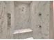 Close-up of shower with marble tile, built-in seat and dual shower heads at 9724 Hermit Hollow Ln, Gibsonton, FL 33534