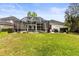 Expansive backyard with lush green lawn, screened-in porch, and outdoor seating area for relaxation and entertainment at 10142 Deercliff Dr, Tampa, FL 33647