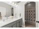 Bathroom featuring a double sink vanity with a large mirror and a shower with a patterned curtain at 10142 Deercliff Dr, Tampa, FL 33647