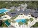 Aerial view of community pool area with multiple pools, clubhouse, and palm trees, offering resort-style amenities at 10142 Deercliff Dr, Tampa, FL 33647