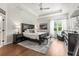 Spacious main bedroom featuring tray ceilings, a ceiling fan, wood flooring, and a gray rug at 10142 Deercliff Dr, Tampa, FL 33647