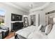 Main bedroom showcasing tray ceilings, a ceiling fan, wood flooring, and a TV at 10142 Deercliff Dr, Tampa, FL 33647