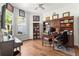 Bright home office featuring a hardwood floor, large windows, and built-in bookshelves and desk at 10142 Deercliff Dr, Tampa, FL 33647