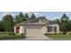 Charming single-story home with a well-manicured lawn, featuring a two-car garage and traditional architectural details at 10258 Gentle Rain Dr, Land O Lakes, FL 34638