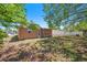 View of the backyard and rear facade of the house with a grass yard, tree, and partial fence at 1051 Normandy Blvd, Holiday, FL 34691