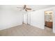 Spacious bedroom with bathroom access, ceiling fan, and tile flooring at 1051 Normandy Blvd, Holiday, FL 34691