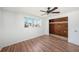Bedroom featuring laminated flooring, ceiling fan, closet space, and natural light at 1051 Normandy Blvd, Holiday, FL 34691