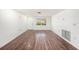 Bright, empty living room featuring wood-look flooring, a white door, and a window at 1051 Normandy Blvd, Holiday, FL 34691
