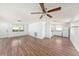 Open living room flowing into kitchen with ceiling fan, white walls, and wood-look flooring at 1051 Normandy Blvd, Holiday, FL 34691