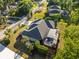 Aerial view featuring a home with a screened-in pool and patio area, surrounded by lush greenery at 10726 Miracle Ln, New Port Richey, FL 34654