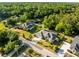 Aerial view of a home with screened in pool, surrounded by mature trees and landscaping at 10726 Miracle Ln, New Port Richey, FL 34654