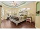 The main bedroom has wood floors, a tray ceiling, and windows for natural light at 10726 Miracle Ln, New Port Richey, FL 34654