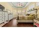 Main bedroom featuring three windows, wood floors, and dressers at 10726 Miracle Ln, New Port Richey, FL 34654
