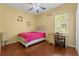 Cozy bedroom features hardwood floors, a ceiling fan, and natural light at 10726 Miracle Ln, New Port Richey, FL 34654