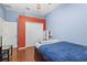 Blue bedroom with wood floor and closet with extra storage cabinets and desk at 10726 Miracle Ln, New Port Richey, FL 34654