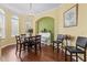 Elegant dining room with a chandelier, piano, and natural light at 10726 Miracle Ln, New Port Richey, FL 34654