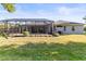 Expansive backyard showcasing a screened-in patio connected to a charming single-Gathering home at 10726 Miracle Ln, New Port Richey, FL 34654
