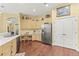Bright kitchen featuring light wood cabinets, a stainless steel refrigerator, and a desk nook near pantry doors at 10726 Miracle Ln, New Port Richey, FL 34654